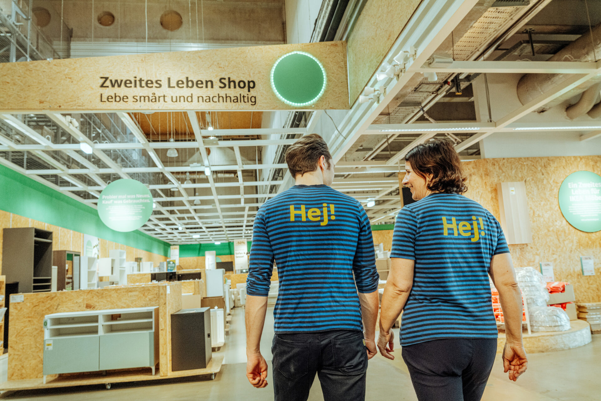 Zwei IKEA Mitarbeiter:innen gehen ins Zweites Leben Shop in IKEA